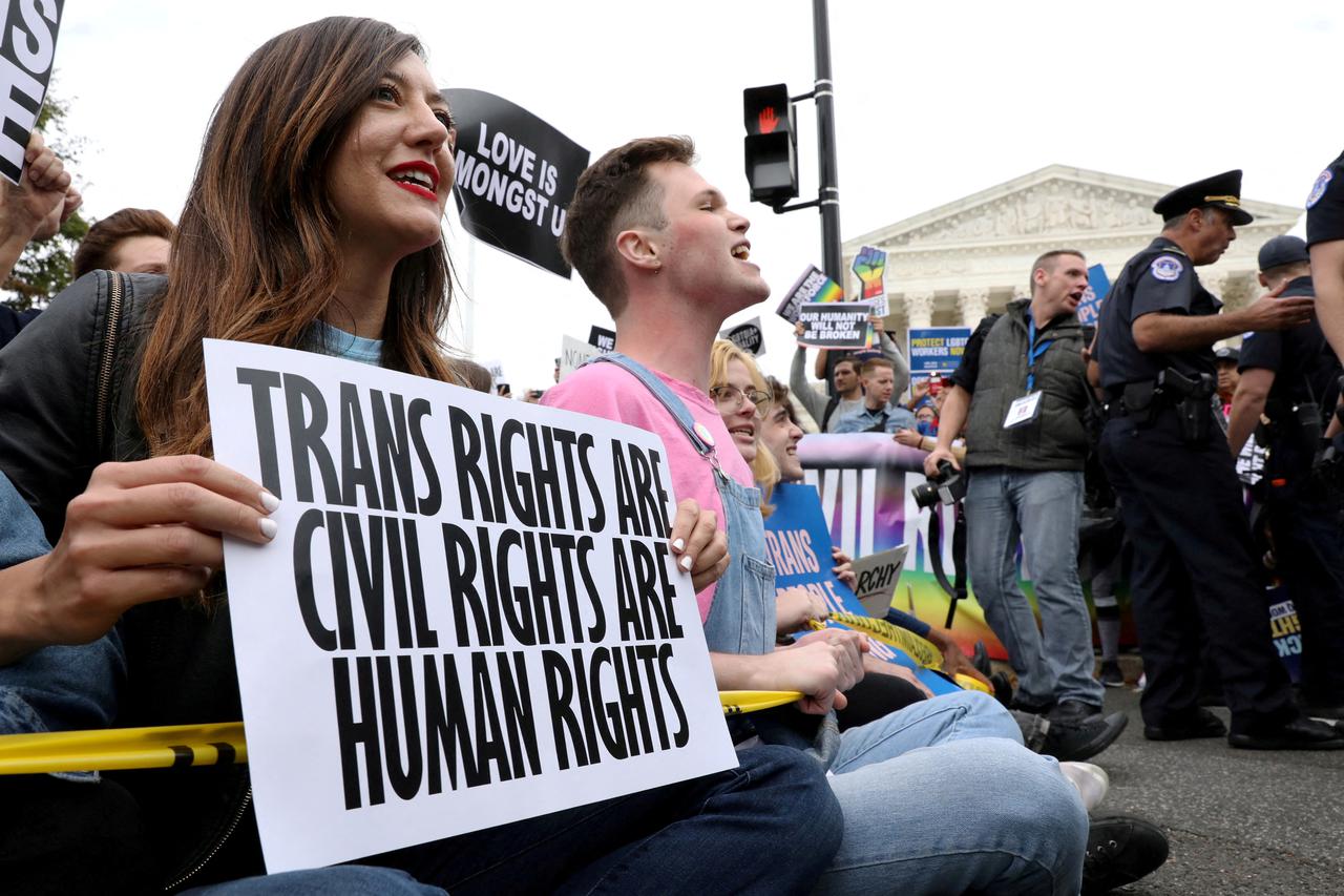 FILE PHOTO: LGBTQ activists and supporters block the street outside the U.S. Supreme Court as it hears arguments in a major LGBT rights case in Washington