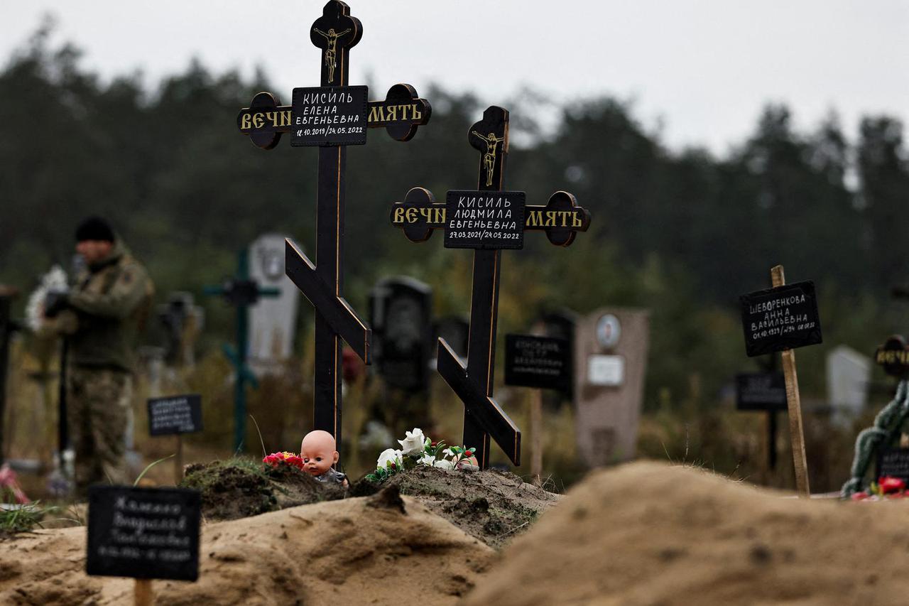 A doll is seen among graves  which Ukrainian officials say is a civilian  mass grave, in the newly recaptured town of Lyman