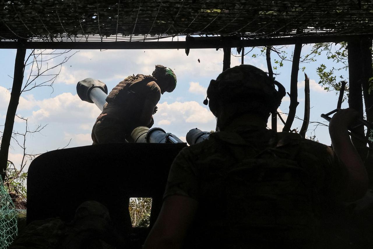Servicemen of the National Guard of Ukraine prepare to fire a howitzer towards Russian troops near the frontline town of Dobropillia