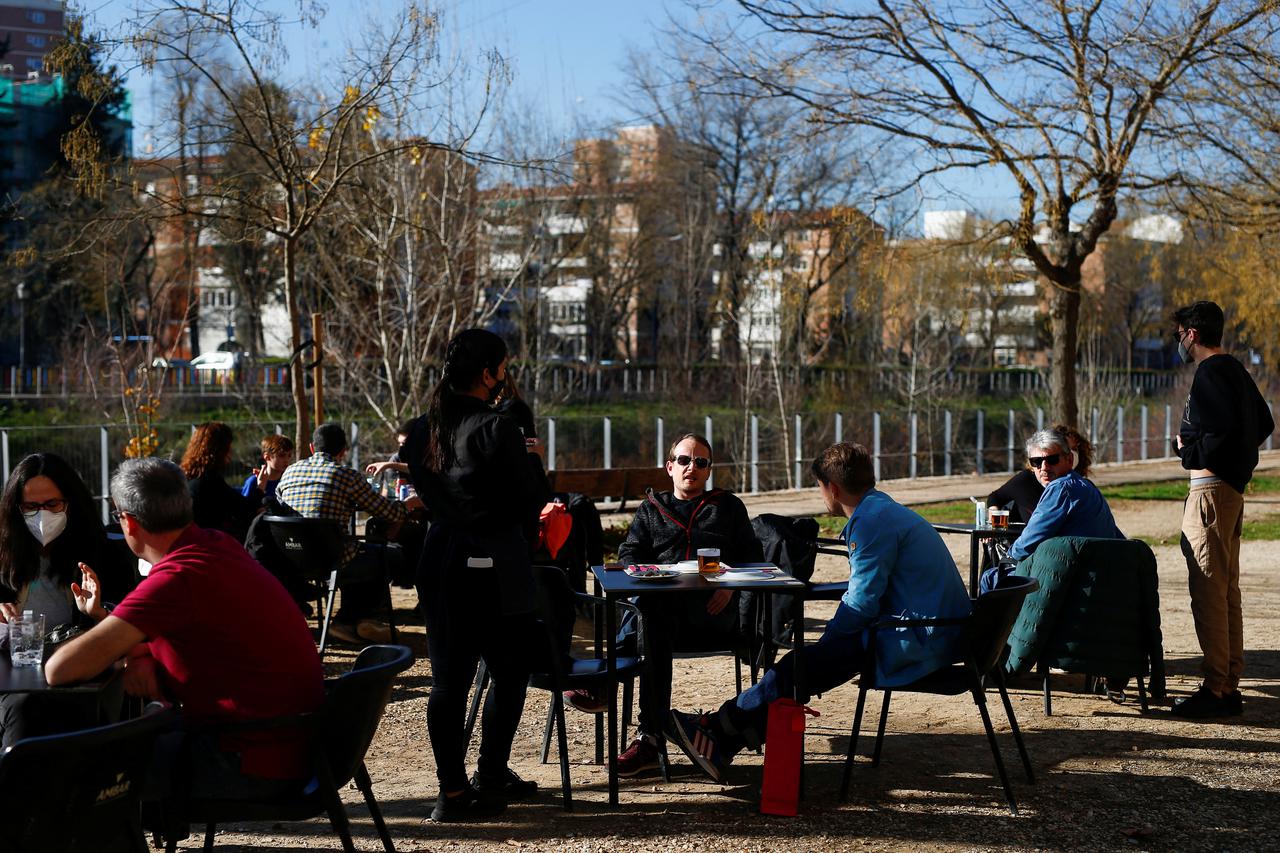 A waiter attends to customers on the terrace of Asador Extremeno restaurant in Madrid