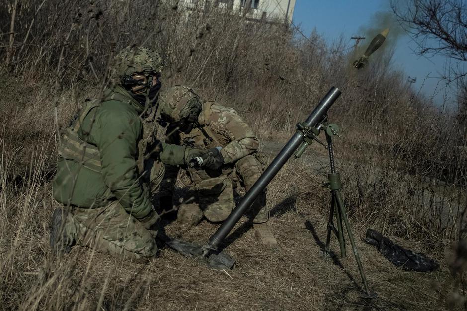 Ukrainian servicemen fire a mortar on a front line in Bakhmut