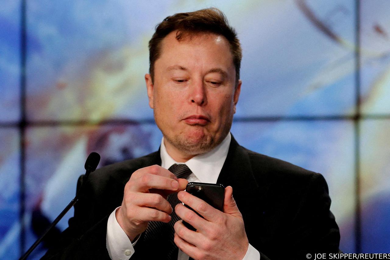 FILE PHOTO: Elon Musk looks at his mobile phone