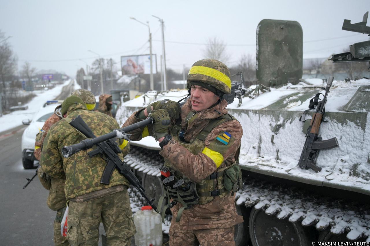 Ukrainian servicemen stand guard on a road in Kharkiv