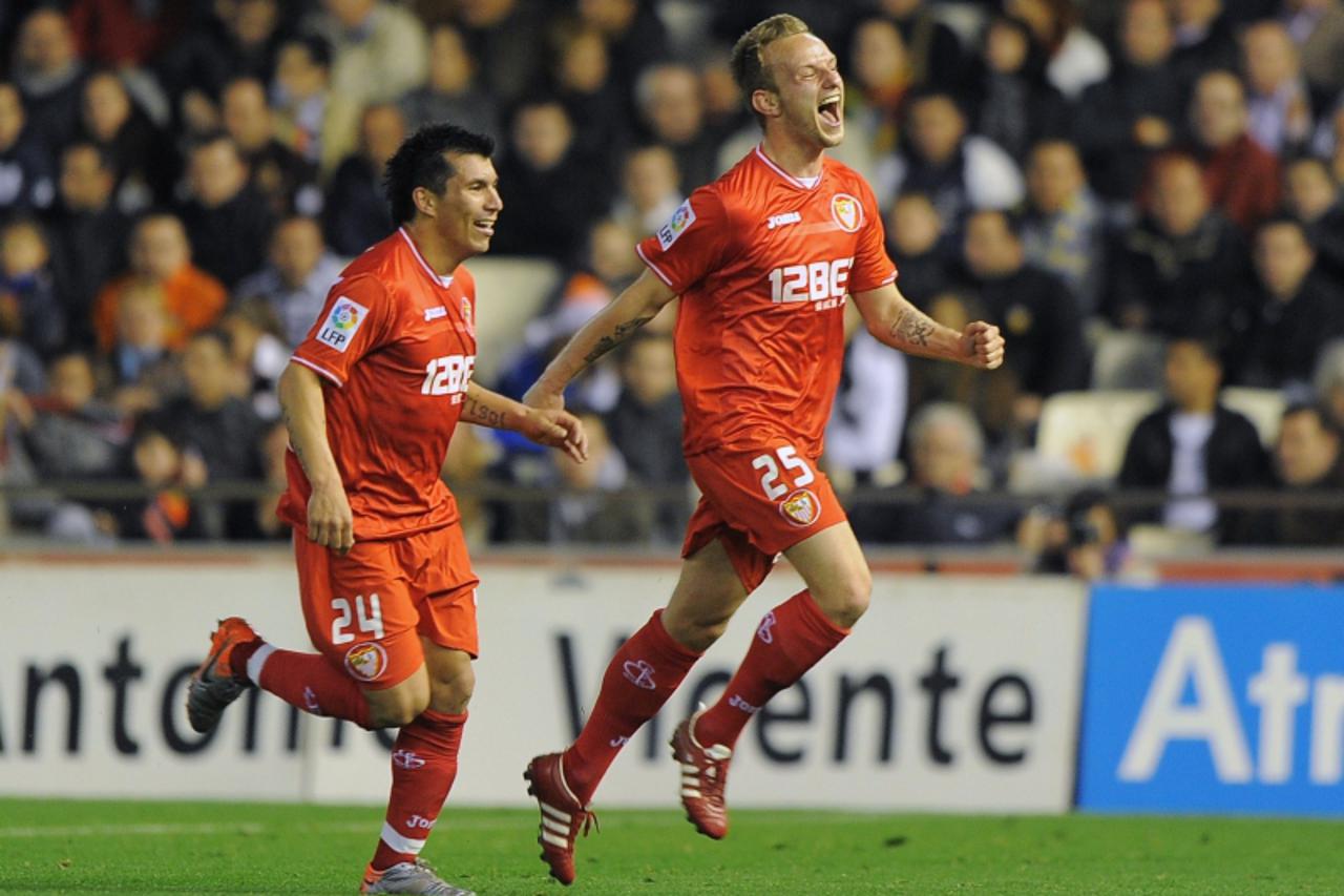 'Sevilla\'s Croatian midfielder Ivan Rakitic (R) celebrates his goal with Sevilla\'s Chilean midfielder Gary Medel during the Spanish league football match Valencia CF vs Sevilla CF on March 20, 2011 