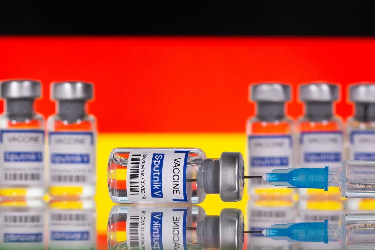 Vials labelled "Sputnik V Coronavirus COVID-19 Vaccine" and a syringe are seen in front of a displayed German flag, in this illustration photo